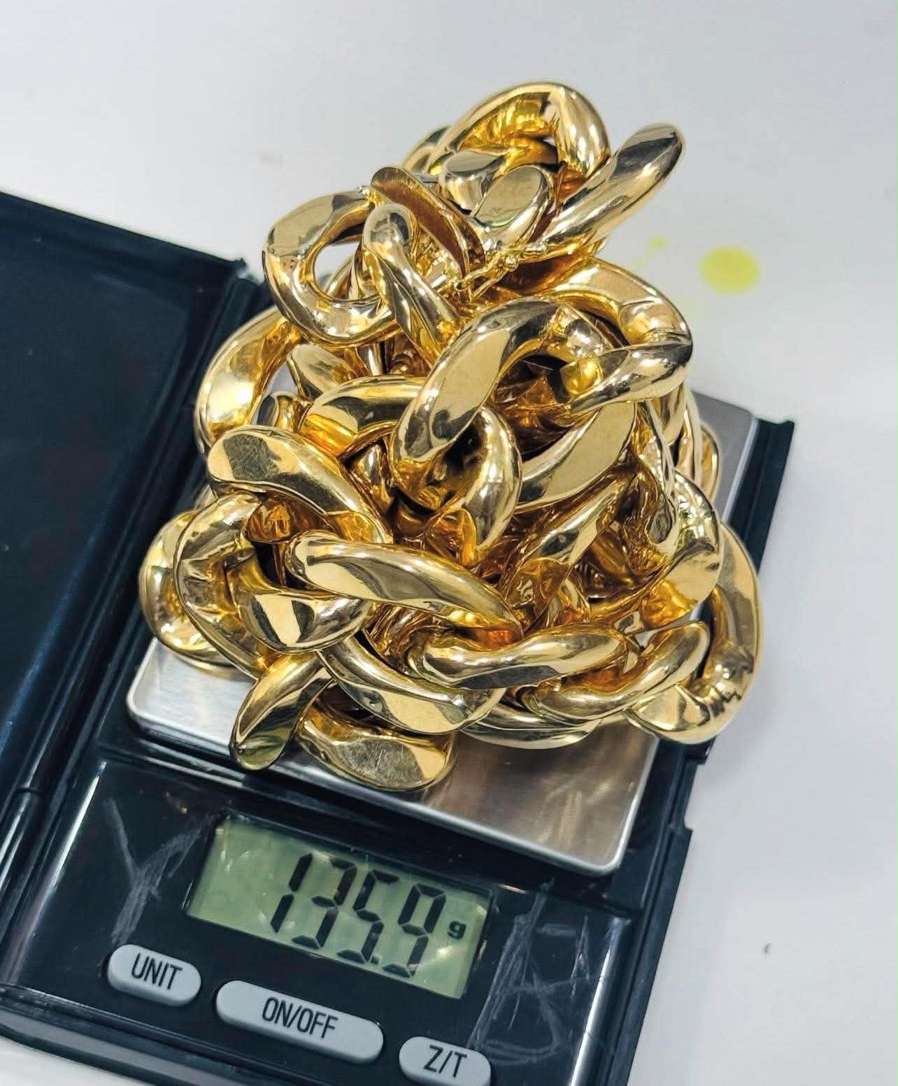Heavy gold rope chain being weighed on a scale